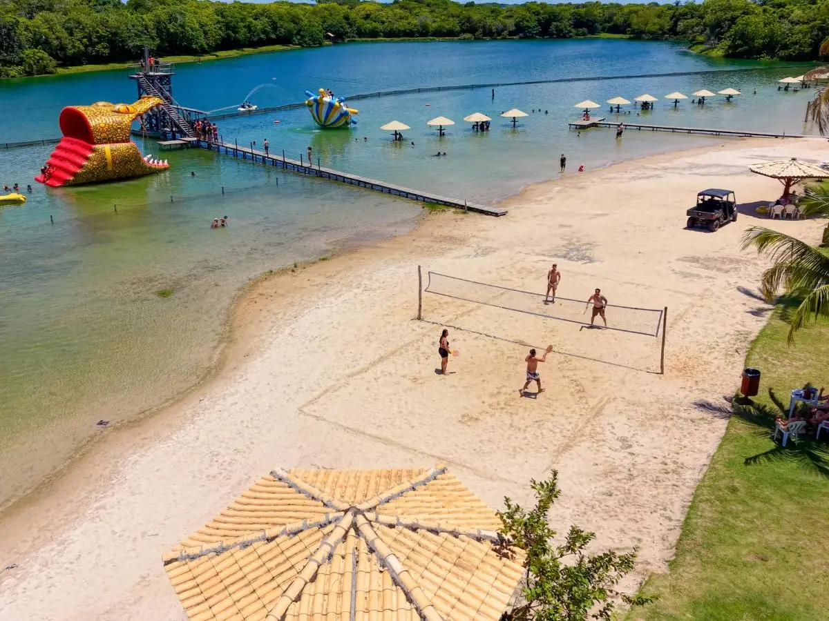 Natural sand beach with volleyball and waterslides in the background at Praia da Figueira