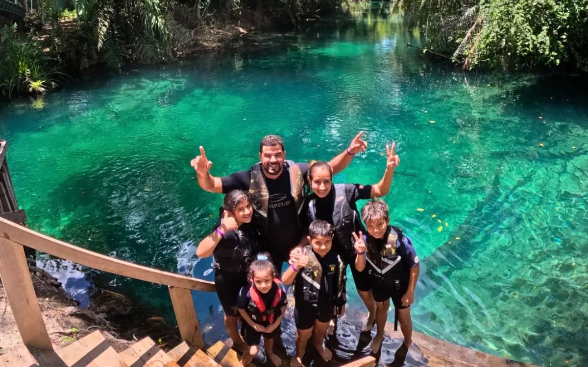 Whole family float trip, wearing life vests in the crystal-clear water at Praia da Figueira, Bonito-MS